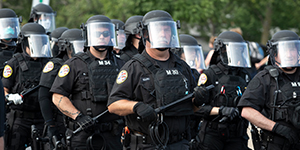 Line of law enforcement officers in protective equipment.
